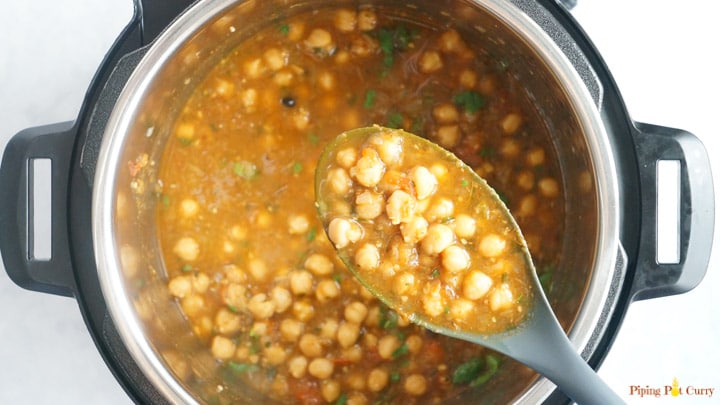 Punjabi Chole Masala / Chana Masala / Chickpeas Curry is a favorite Indian dish. This one-pot recipe for the authentic Chana Masala can be made in the Instant Pot or stovetop Pressure Cooker. A healthy protein-rich vegan and gluten free chickpea recipe. Pressure cooker Chole Masala cooked in a ladle over the instant pot