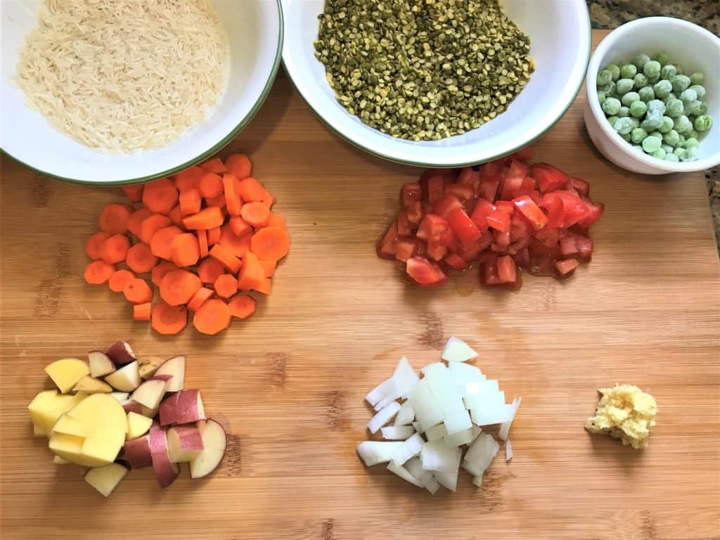 Lentil & Vegetable Khichdi or Masala Khichdi recipe made in Instant Pot or Pressure Cooker. A one-pot vegetarian comfort meal made with lentils, rice and vegetables along with simple spices and ghee | #khichdi #instantpot #pressurecooker #glutenfree Pressure Cooker Masala Khichdi Ingredients - Rice, Split Green Lentils, Green Peas, Carrots, Potatoes, Onions, Tomatoes, Ginger