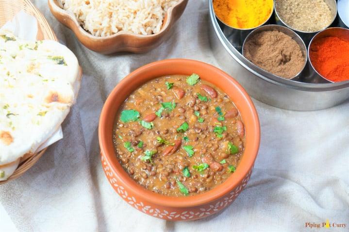 Dal Makhani made in the instant pot, served in a earthen pot with some brown rice and spices in the back