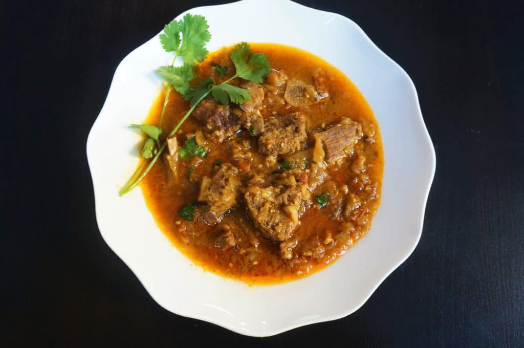 Goat Curry or Mutton Masala in the Instant Pot or Pressure Cooker. Tender meat cooked in an onion tomato gravy with aromatic whole spices