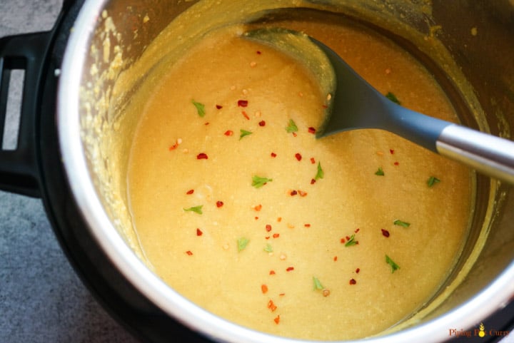 Vegan Turmeric Cauliflower Soup made in the Instant Pot in less than 30 minutes. Cooked & pureed Turmeric Cauliflower Soup made in the instant pot garnished with red chili flakes and parsley