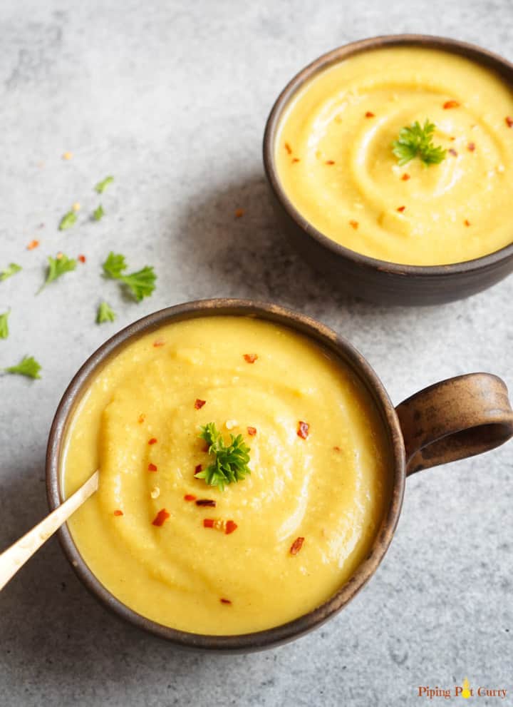 Vegan Turmeric Cauliflower Soup made in the Instant Pot in less than 30 minutes. Turmeric Cauliflower Soup made in the instant pot in 2 serving bowls garnished with red chili flakes and parsley