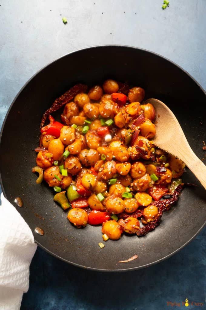 Flavorful and easy Garlic Chili Potatoes, made with steamed potatoes, garlic, chili sauce and honey, sprinkled with green onions and sesame seeds. Enjoy them as an appetizer or side! Garlicky Chili Potatoes - in a wok ready to enjoy