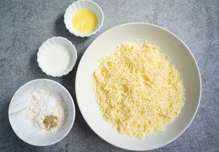 Ingredients to make Gulab Jamun (indian donuts) with Khoya in white bowls