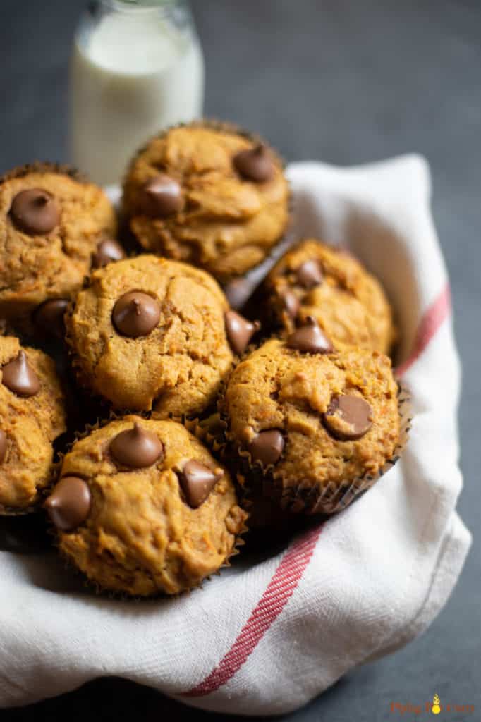 Healthy Carrot Muffins in a basket with a bottle of milk in the back
