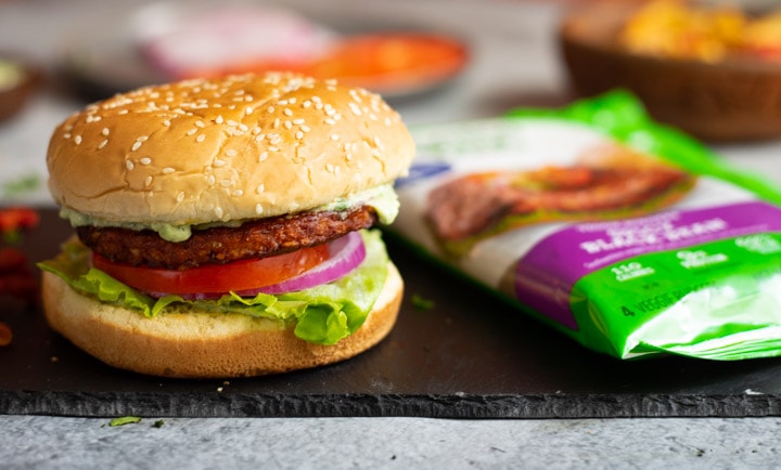 Deliicous burger with a packet of the patties in the background