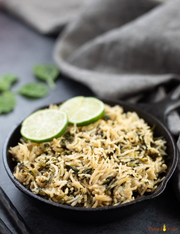 Spinach Rice in a cast-iron pan topped with lemon slices