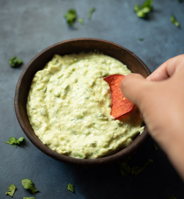 Dipping a chip in a creamy avocado sauce