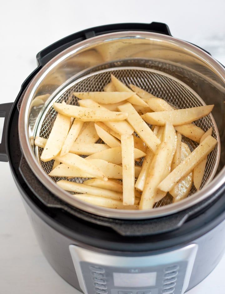 French fries in a mesh basket in an electric pressure cooker