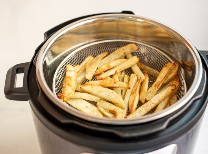 Crispy French Fries in a mesh basket in an electric pressure cooker
