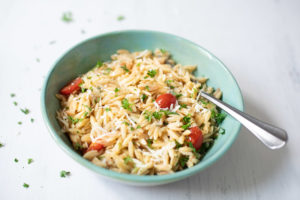 Lemon Parmesan Orzo with tomatoes in a green bowl